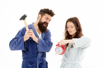 Rage and hate. Early morning anxiety. Get rid of annoying alarm clock. Couple bathrobes going to destroy alarm clock and stay at home. Breaking rules. Man with hammer beat alarm clock. Hateful sound