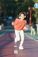 Giving all her best. Having fun. Little girl running outdoor. little girl listen music. Mp3 player. happy little girl. Audio book. Kid in headphones. Fun time. funny child. spring fun. Feeling free