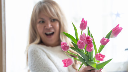 Woman Happy Holding a Bouquet of Pink Tulips in her Hand