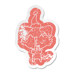 laughing little dog cartoon distressed sticker of a wearing santa hat