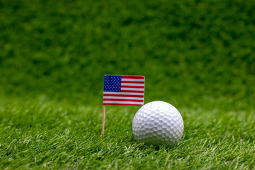 Golf ball with U.S.A. flag are on green grass