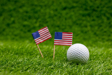 Golf ball with U.S.A. flag are on green grass