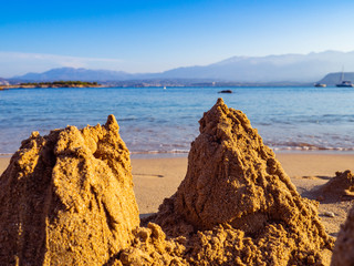 Fototapeta na wymiar Small sand piles on the beach, evening shot