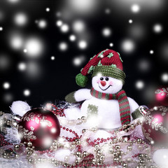 fun toy snowman and Christmas decorations on a black background