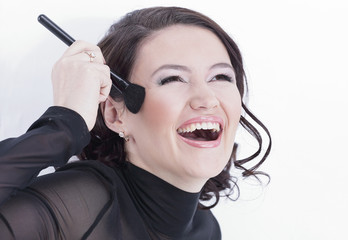 Obraz premium smiling young woman with brush for makeup.