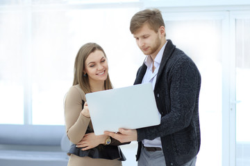 business colleagues use a laptop standing in the office