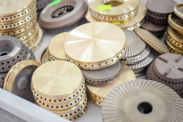 Gas plates spare parts for cooker, product shopping display background. Closeup on golden and gray...