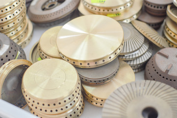 Gas plates spare parts for cooker, product shopping display background. Closeup on golden and gray shiny round shape elements of household appliance.