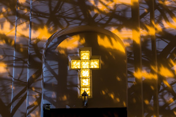 Christian cross on the facade of the church at night