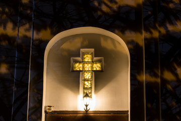 Christian cross on the facade of the church at night