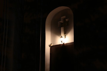 Christian cross on the facade of the church at night
