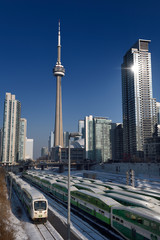 GO trains in downtown Toronto waiting for rush hour with CN tower, Rogers Centre stadium and highrise condominiums
