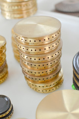 Gas plates spare parts for cooker, product shopping display background. Closeup on golden and gray shiny round shape elements of household appliance.