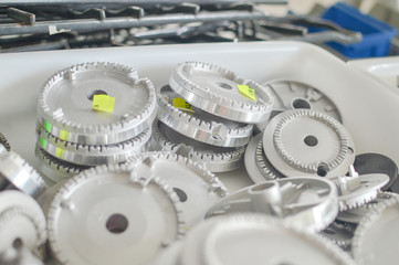 Gas plates spare parts for cooker, product shopping display background. Closeup on golden and gray...