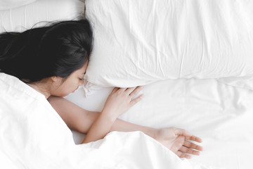 Obraz na płótnie Canvas Woman has a deep sleep on white bed. Concept of tried and rest.
