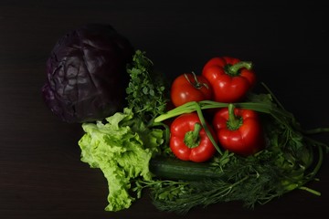 Still life of fresh vegetables. Pumpkin, white cabbage, red cabbage, two tomatoes, large and juicy red sweet peppers, greens of Basil, dill, parsley and green onions, as well as green fresh cucumber 