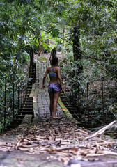 Beautiful girl on a forest hanging bridge