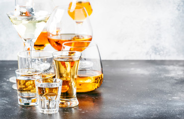 Selection of hard strong alcoholic drinks  and spirits in big glasses and small shot glass in...