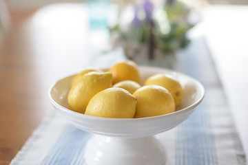 Bowl of lemons on the kitchen table in bright natural light