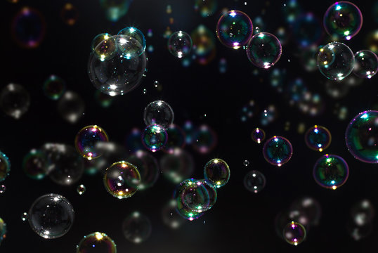 Beautiful colorful soap bubbles floating in the dark.