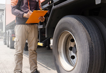 Fototapeta na wymiar Truck Drivers is Checking the Truck's Safety Maintenance Checklist. Lorry Driver. Inspection Truck Safety of Semi Truck Wheels Tires. 