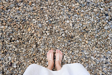Selfie Young Woman of Feet in Fashion Shoes on Stones Floor. Beautiful Girl Standing is Foot & Slim Legs Seen from Above on Road Street. Flat Shoe (Sandal) on Cement Layoknok Background, Top View.
