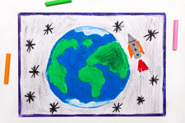 Colorful drawing: Rocket in space, flying next to the planet earth
