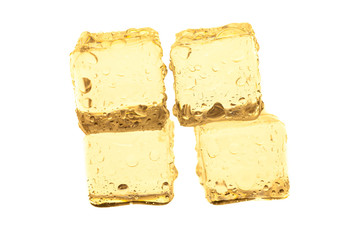 Golden ice cubes on white background.
