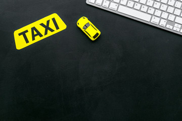 Choose, select taxi concept. Order taxi online. Sign ner car toy and keyboard on black background...