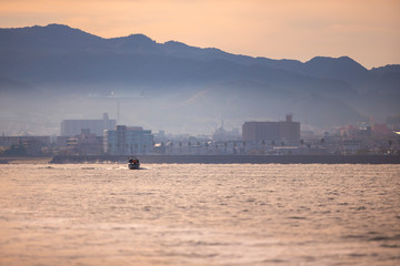 Obraz premium A personal boat running to the sea in warm light at Osaka bay, Japan