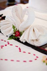
Alamy
Two swans made of towels on bed in honeymoon suite colorful room hotel decorated for wedding or just married people