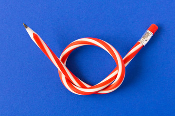 Flexible pencil . Isolated on blue background. Bending pencil.