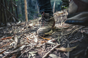 Close up traveller shoes walking in forest. travel concept.