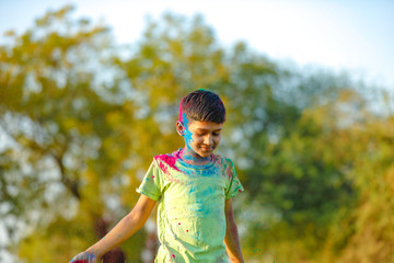 Indian child playing with the color in holi festival