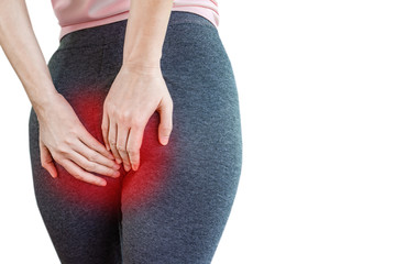 woman hand holding her painful butt caused by hemorrhoids isolated on white background 