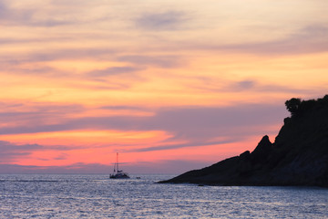 Dark silhouettes of palm trees and amazing cloudy sky on sunset at tropical island 