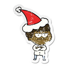 distressed sticker cartoon of an annoyed man wearing santa hat