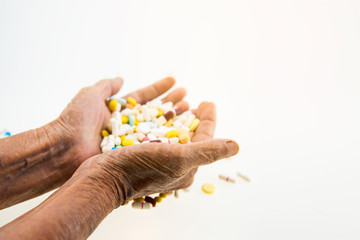 Elderly hand holding a lot of drugs.
