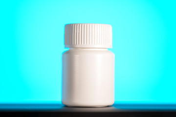 white bottle of pills on blue background