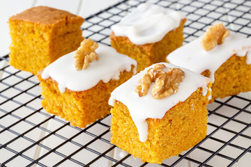 Pieces homemade walnut carrot cake with icing cream white plate. Selective focus. Close up. Top view.