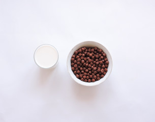 Breakfast Cereal  on white background.  Milk glass top view. Natural ingredients concept. Tasty healthy products on a table,selective focus. Dry breakfast cereals.Chocolate cereal balls on white.