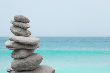 Stack of stones near water. Space for text