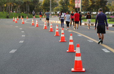 Closeup of traffic poles, traffic lane, jogging track on the street and walkers with natural background in twilight evening. 