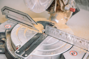 Miter saw. Cut off the boards on the saw. Facing the boards. Tool for carpentry work.