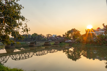Obraz premium Iron bridge in Chiangmai during sunset time with beautiful lens flare.