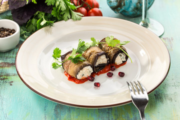 Eggplant rolls stuffed with cottage cheese and walnuts on blue wooden table
