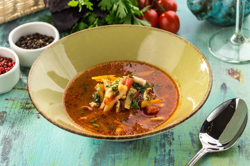 Tomato soup with fresh vegetables and sausages on blue wooden table