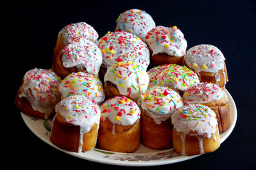 aster cakes on a black background decorated with multicolored food powder.