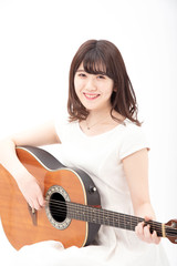 笑顔でアコーステックギターを弾く女性