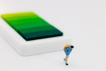 Miniature people: Traveller with backpack walking on the path of tourism. Travel, explore and adventure concept